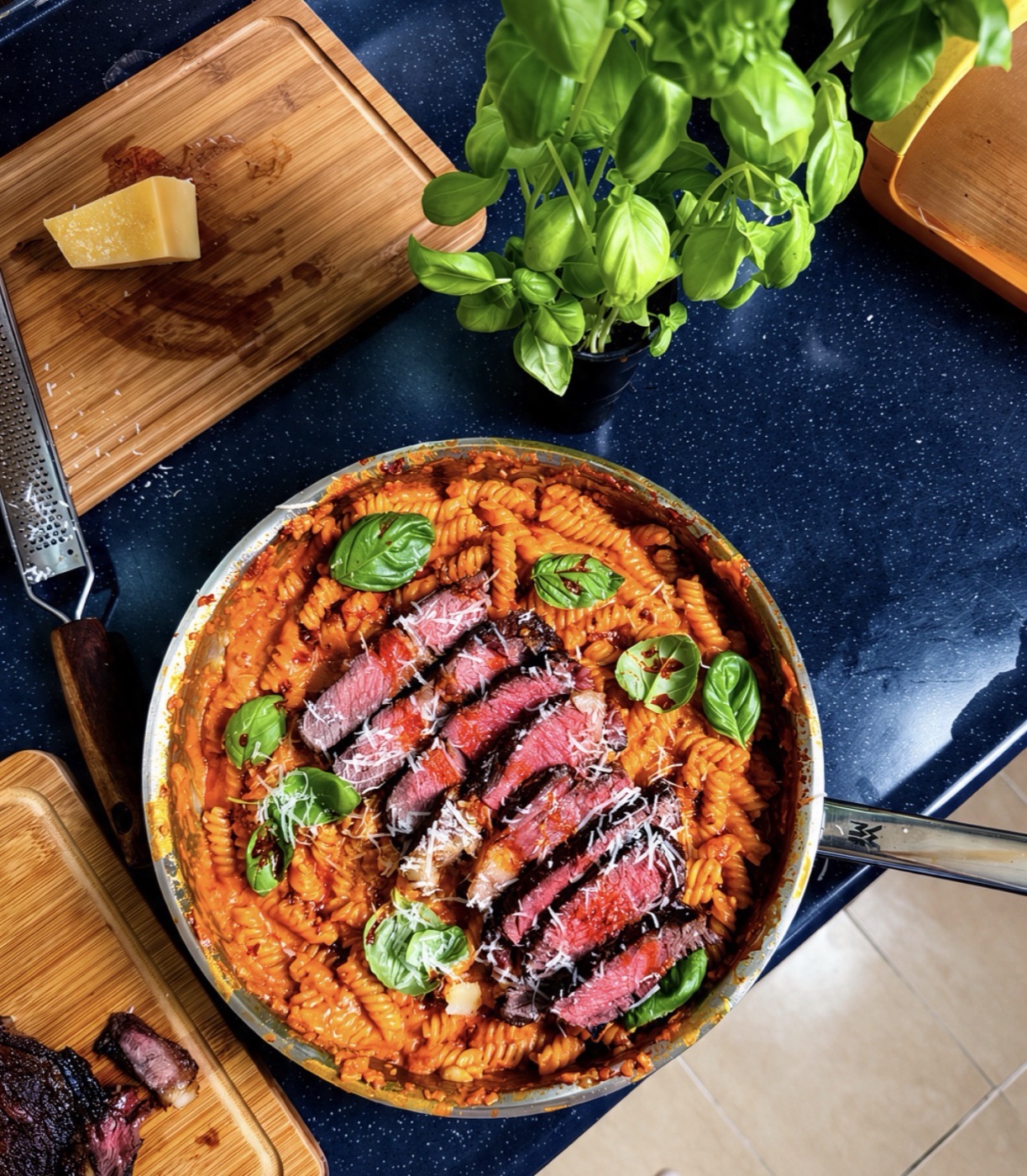 Pasta topped with sliced steak and basil, photographed by Mazin